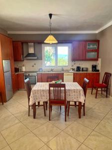 a kitchen with a table and some chairs and a table and a kitchen at Villa Melissani in Karavomylos