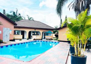 a swimming pool in front of a house at Mika Lodge in Lusaka