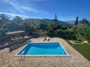 a swimming pool in a yard with a mountain at Villa Melissani in Karavomylos