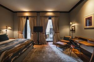 a hotel room with a bed and a desk at Valverde Lisboa Hotel & Garden - Relais & Chateaux in Lisbon