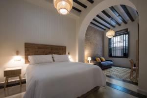 a bedroom with a large white bed in a room at Casa Tomás Boutique Hotel in Seville