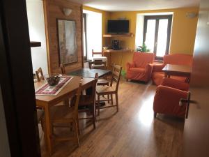 a kitchen and living room with a table and chairs at Indren Hus in Alagna Valsesia