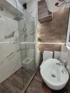 a bathroom with a glass shower and a sink at Апартамент Top Central in Yambol