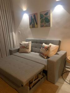 a couch with pillows on it in a room at Chalé I - Village da Serra in Serra de São Bento