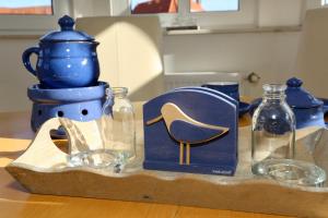 a table with three glass bottles and a blue pitcher at Turmwohnung 205 in Juist