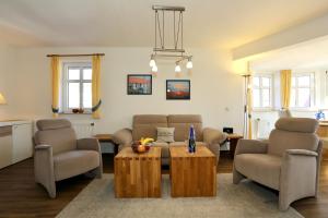a living room with a couch and chairs and a table at Turmwohnung 205 in Juist