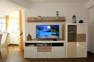 a living room with a tv on a white entertainment center at Turmwohnung 205 in Juist