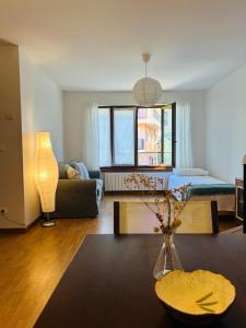 a living room with a bed and a living room with a table at Casa de la Tila in Arenas de Cabrales