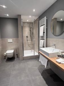 a bathroom with a shower and a sink and a toilet at Hotel Ratsstuben in Lindau +64 photos