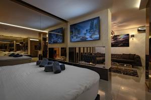 a bedroom with two beds and a tv on the wall at Aura Villas Skopje in Skopje