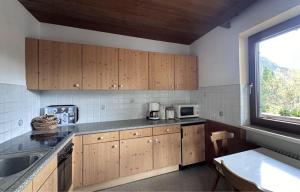 a kitchen with wooden cabinets and a window at Chalet Villa Josi Superior Appartement 12 in Leutasch +19 photos