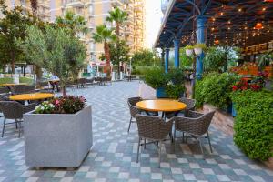 an outdoor patio with tables and chairs and plants at Hotel Adria 2 Shengjin in Shëngjin