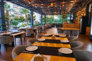 a restaurant with wooden tables and chairs and people eating at Hotel Adria 2 Shengjin in Shëngjin