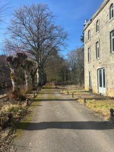an empty road next to an old stone building at Maison Aline in Hotton