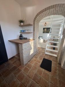 a living room with a brick fireplace and a staircase at Maison Aline in Hotton +3 photos