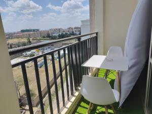 a balcony with a white table and a white chair at 4 Bedroom Apartment Near JKIA & SGR in Nairobi