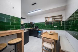 a kitchen with green tiles on the walls and a table at Casa Tomás Boutique Hotel in Seville +38 photos