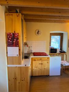 a kitchen with wooden cabinets and a white refrigerator at La Casetta di Cri Morbegno in Morbegno