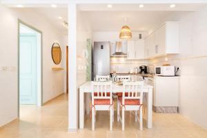 a kitchen with a white table and chairs at Profithome-Punta Larga in Candelaria