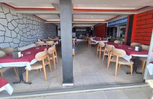 a restaurant with tables and chairs in a room at mavikumsal otel in Kumburgaz