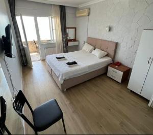 a bedroom with a bed and a chair in it at mavikumsal otel in Kumburgaz +5 photos