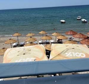 a group of umbrellas on a beach with the ocean at mavikumsal otel in Kumburgaz