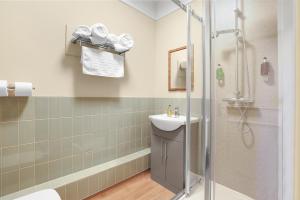 a bathroom with a shower and a toilet and a sink at The Slow & Easy in Lostock Gralam