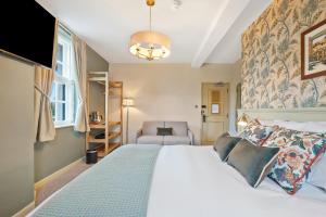 a bedroom with a large bed and a chair at The Slow & Easy in Lostock Gralam
