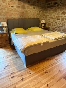 a large bed with yellow pillows in a bedroom at La maison dans les prés in Labaroche