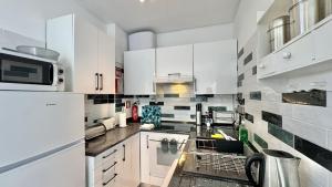 a kitchen with white cabinets and white appliances at Arrifana Sea Stay in Aljezur