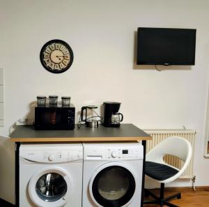 a room with a washing machine and a clock on the wall at Chillout Zone Neuss - Apartment mit Balkon in Neuss