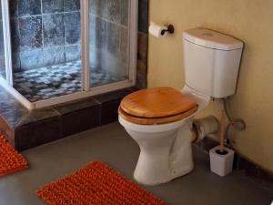 a bathroom with a shower with a toilet with a wooden seat at Akasia - 333 in Hoedspruit +32 photos