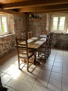 a dining room with a wooden table and chairs at La maison dans les prés in Labaroche