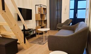 a living room with a couch and a tv and stairs at Palác Apartment in Strakonice
