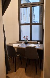 a table with two chairs and a window at Palác Apartment in Strakonice
