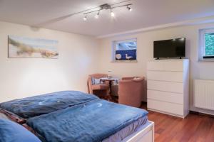 a bedroom with a bed and a flat screen tv at Am Waldrand in Radis