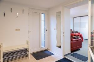 a living room with a red chair and a mirror at Am Waldrand in Radis