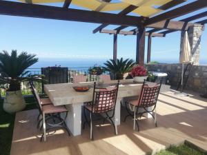 a table and chairs on a patio with a view of the ocean at Casa Olimpia - Mareri apartments in Poggi