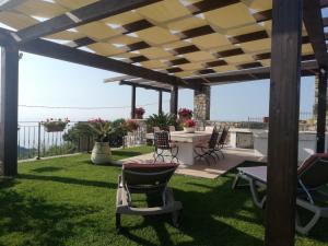 a patio with a table and chairs on the grass at Casa Olimpia - Mareri apartments in Poggi