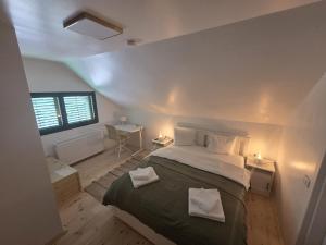 a bedroom with a large bed with two pillows at La casa morarului in Cârțișoara