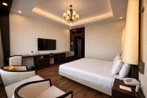 a bedroom with a bed and a desk and a television at Clarks Avadh in Lucknow