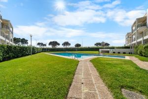 an image of a swimming pool in a park with grass at Houten Apartment Apulia in Apúlia