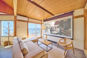 a living room with a couch and a large window at プライベートリゾート清風 in Atami