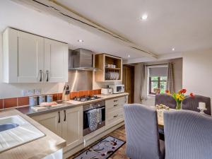 a kitchen with white cabinets and a table with chairs at 2 Bed in Thetford oc-57886 in Saham Toney