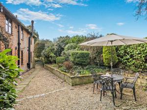 a table and chairs with an umbrella in a garden at 2 Bed in Thetford oc-57886 in Saham Toney