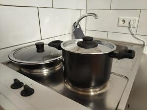 two pots and pans on a stove in a kitchen at Chillout Zone Neuss - Apartment mit Balkon in Neuss