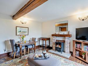 a living room with a table and a fireplace at 1 Bed in Thetford oc-57889 in Saham Toney