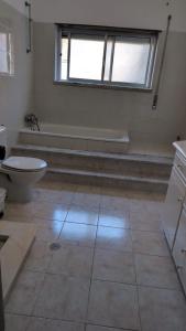 a bathroom with a toilet and a bath tub at Cozy rooms in Minde, Fatima in Minde