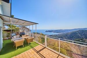 a balcony with chairs and a view of the ocean at プライベートリゾート清風 in Atami
