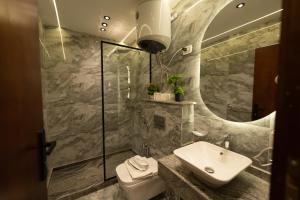 a bathroom with a sink and a toilet and a mirror at The Muse Luxury View Hotel in Cairo